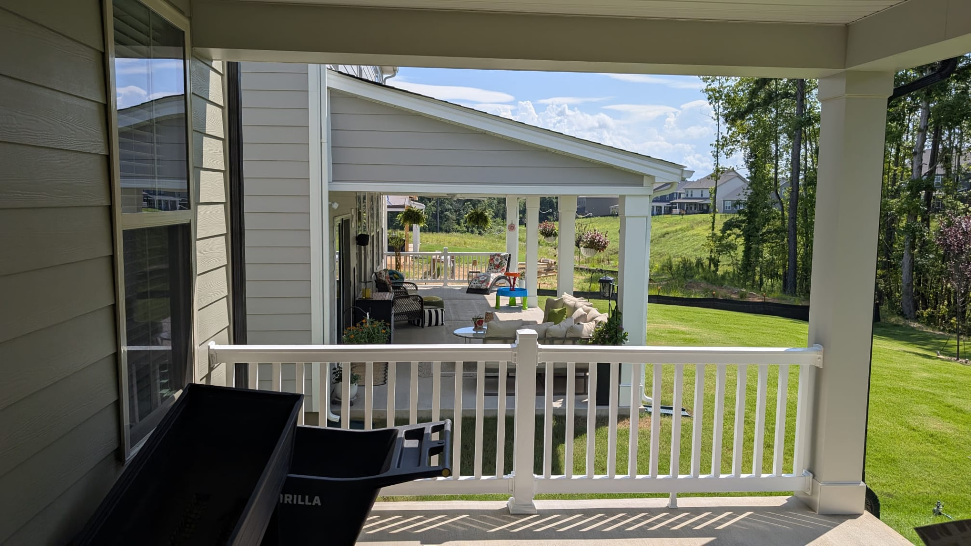 White porch railings overlooking the backyard from an upper porch