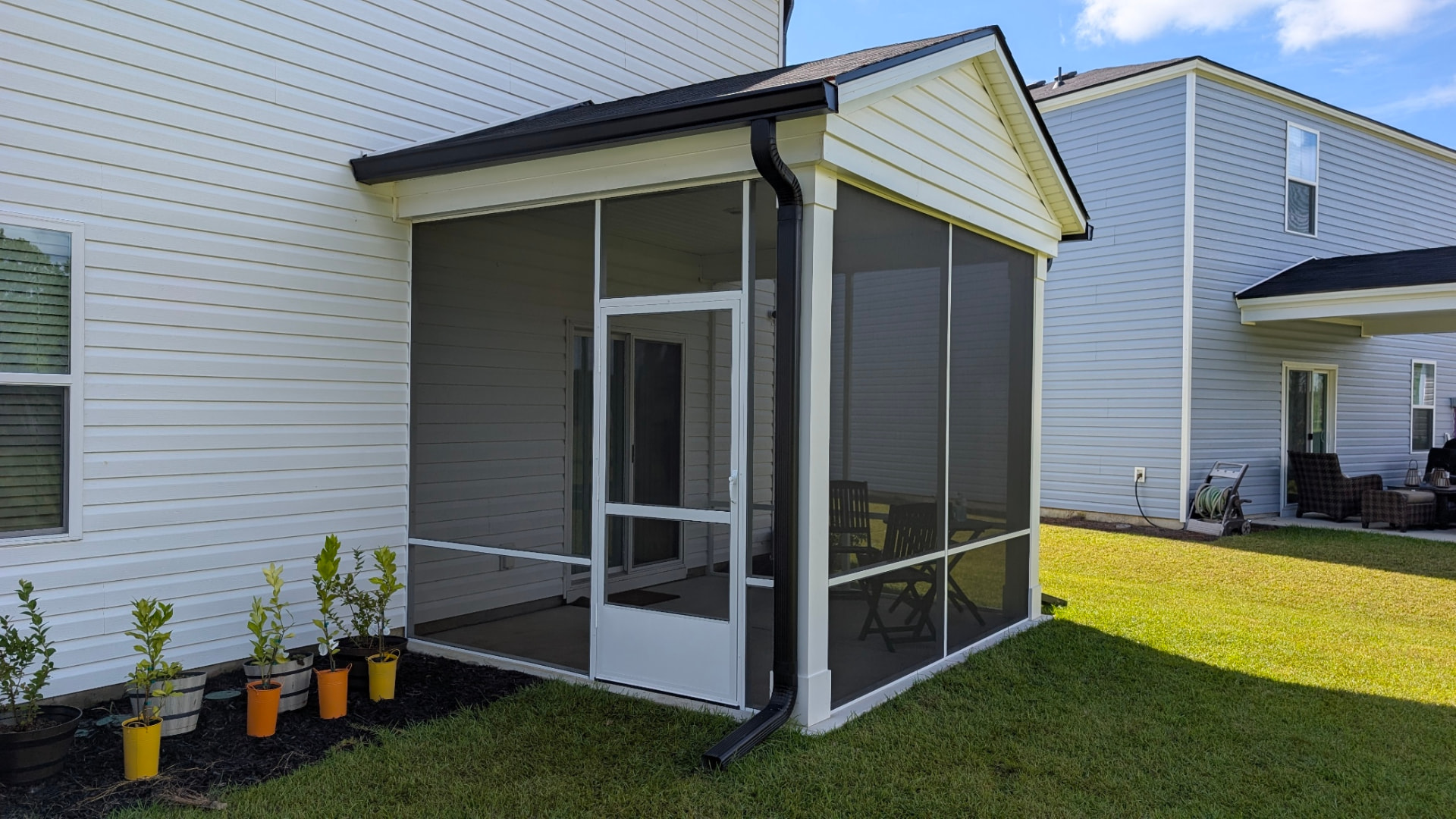 Screened Porch: Gabled screened addition with black gutters